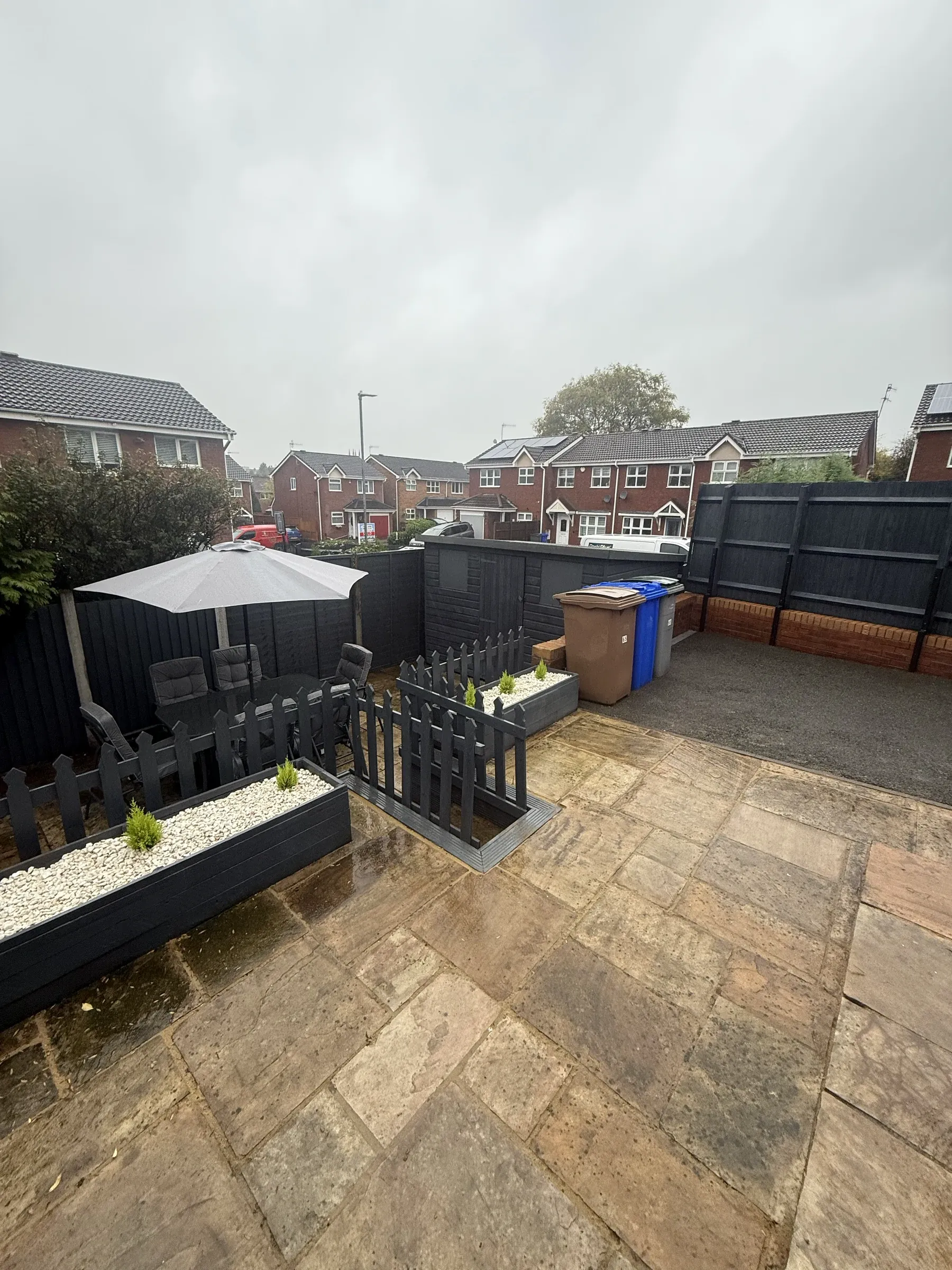 A rear garden with new flagged patio, fencing and planting after refurbishment