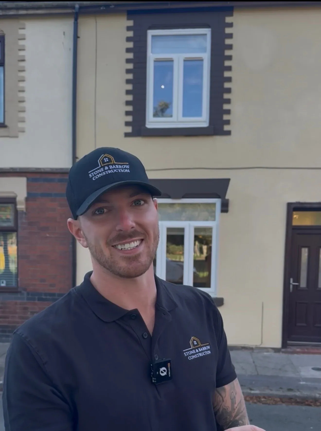 A member of the Stone & Barrow team in a branded polo shirt, outside a terraced property