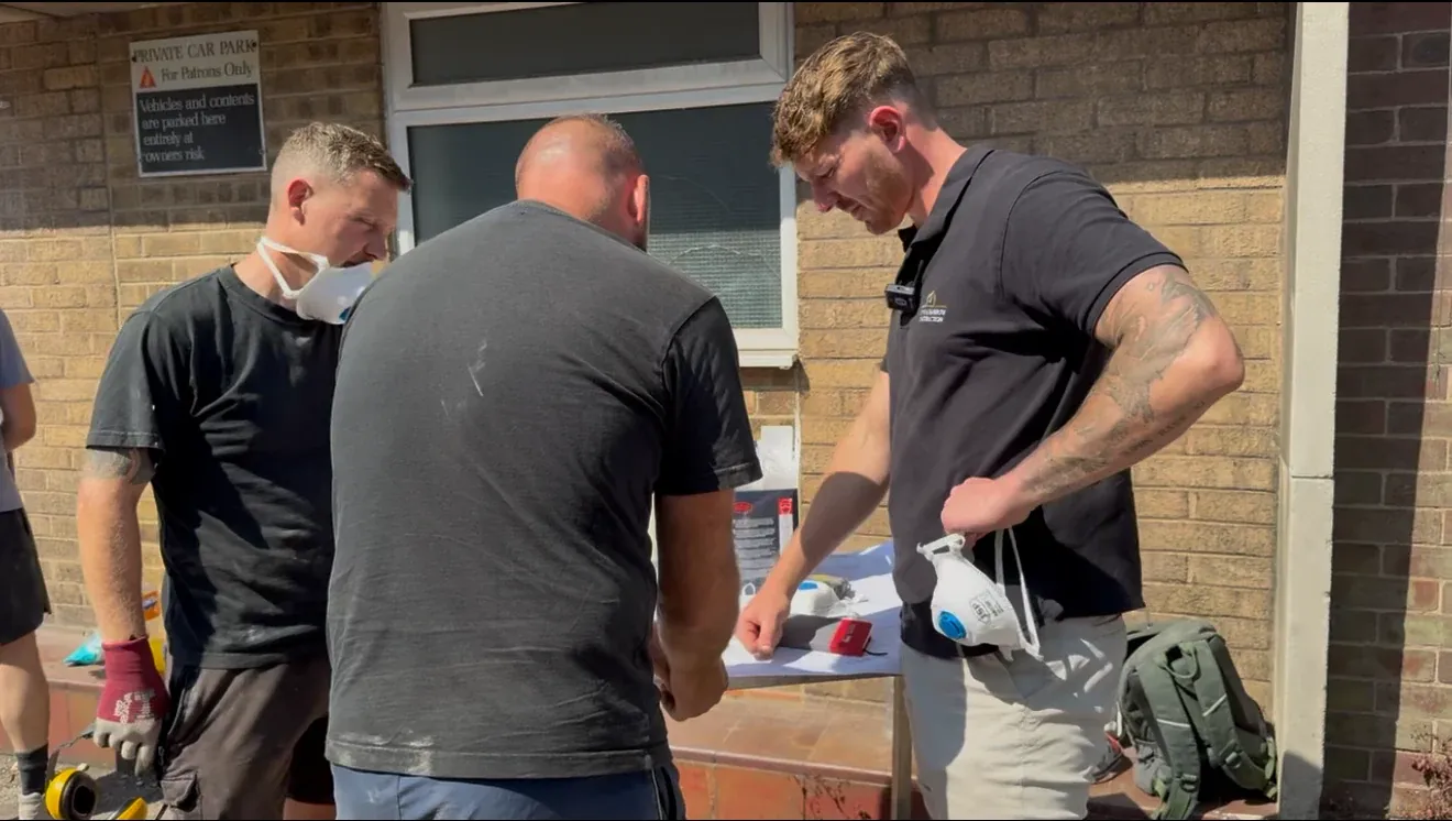 The Stone & Barrow team going through the day's work at a bench outside a property