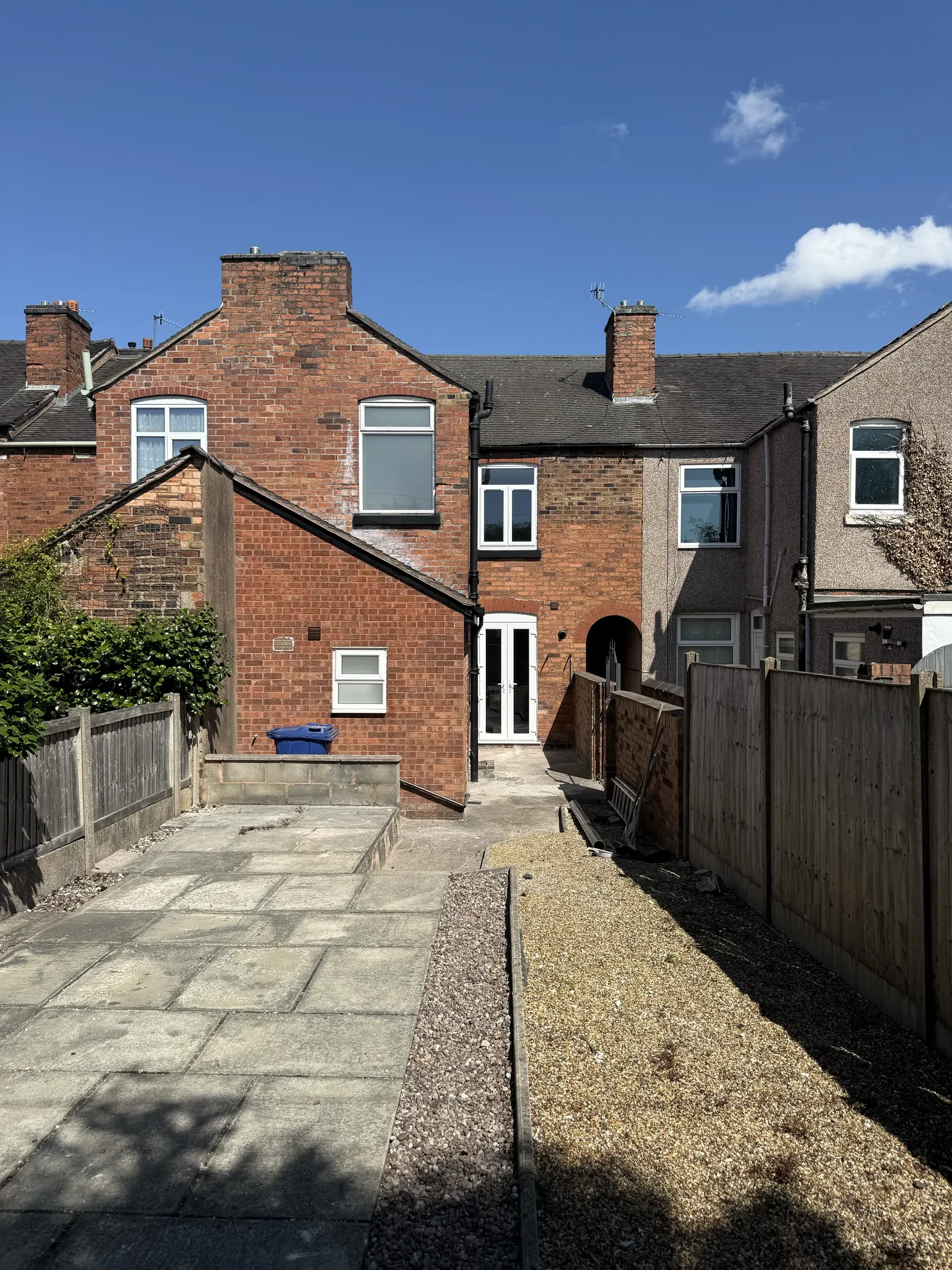 The rear elevation and yard, with new paving and fencing
