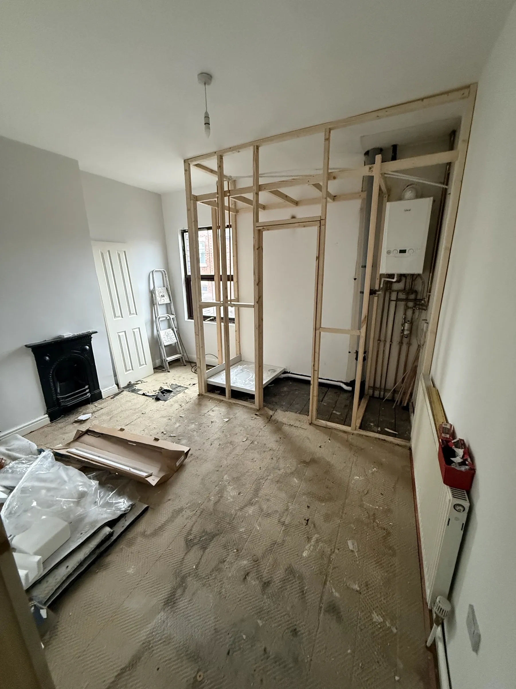 A room at first fix, with new stud framing around the boiler and pipework run in